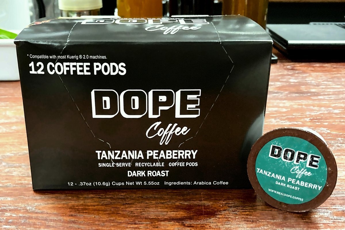 A box of Dope Tanzania Peaberry coffee pods and a pod on the counter